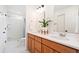 Bathroom featuring a double vanity with wood cabinets and a separate shower room at 10254 Worchester St, Commerce City, CO 80022