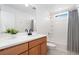 Bright bathroom featuring wood cabinets, white countertops, and shower over tub at 10254 Worchester St, Commerce City, CO 80022