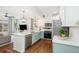 Bright, open kitchen with white cabinets, stainless appliances, and quartz counters flowing into the adjacent living space at 10254 Worchester St, Commerce City, CO 80022