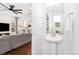 Stylish powder room with pedestal sink and view into a living room and kitchen at 10254 Worchester St, Commerce City, CO 80022