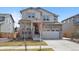 Charming two-story home showcasing a stone facade, covered porch, and a well-maintained lawn and driveway at 24432 E Tennessee Pl, Aurora, CO 80018