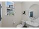 Cozy half bathroom with modern fixtures, a decorative mirror, and a bright window at 24432 E Tennessee Pl, Aurora, CO 80018