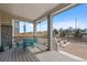 Inviting covered porch with comfortable seating and scenic views of the outdoor fireplace and yard at 24432 E Tennessee Pl, Aurora, CO 80018
