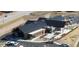 Aerial view of a modern building with a dark roof, solar panels, ample parking, and green space at 6 Woodland Cir, Highlands Ranch, CO 80126