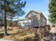 Back of home features a fenced yard and covered porch and stairs to backyard at 6 Woodland Cir, Highlands Ranch, CO 80126