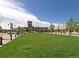 A picturesque view of a community green space with a clock tower and surrounding storefronts at 6 Woodland Cir, Highlands Ranch, CO 80126