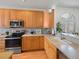 Bright kitchen featuring stainless steel appliances, wood cabinets, and eat-in countertop seating at 6 Woodland Cir, Highlands Ranch, CO 80126