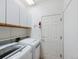 Laundry room featuring white cabinets, a white door, and a modern washing machine and dryer at 6 Woodland Cir, Highlands Ranch, CO 80126