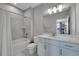 Bright bathroom with a tub, shower, white cabinets, a framed mirror, and white countertops at 6211 W 28Th Ct, Wheat Ridge, CO 80214