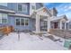 View of a blue townhome with a red door and white trim during a snowy day at 6211 W 28Th Ct, Wheat Ridge, CO 80214