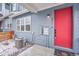 Close up on a blue townhome with a bright red front door and snowy yard at 6211 W 28Th Ct, Wheat Ridge, CO 80214