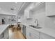 Bright eat-in kitchen features a stainless steel sink, white countertops and cabinets, stainless steel appliances, and hardwood floors at 6211 W 28Th Ct, Wheat Ridge, CO 80214