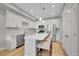 Modern kitchen features stainless steel appliances, white cabinetry, a large center island with seating, and quartz countertops at 6211 W 28Th Ct, Wheat Ridge, CO 80214