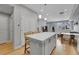 The kitchen island features bar stool seating, modern white cabinets, and stainless steel appliances, with a view to the living area at 6211 W 28Th Ct, Wheat Ridge, CO 80214