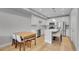 Modern eat-in kitchen with stainless steel appliances, quartz countertops, kitchen island, and a dining area with a wood table at 6211 W 28Th Ct, Wheat Ridge, CO 80214