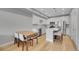 Modern white kitchen with stainless steel appliances, a kitchen island, and a dining area at 6211 W 28Th Ct, Wheat Ridge, CO 80214