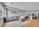 Open floor plan with a gray sectional sofa, hardwood floors, and a view of the kitchen at 6211 W 28Th Ct, Wheat Ridge, CO 80214