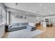 Bright, open-concept living room featuring a plush gray sectional sofa, light hardwood floors, and modern recessed lighting at 6211 W 28Th Ct, Wheat Ridge, CO 80214