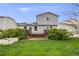 Well-maintained backyard with grass, planted trees, and a deck at 9674 Fox Den Dr, Littleton, CO 80125