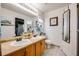 Bathroom featuring double sinks, wooden cabinets, and a large mirror for a functional design at 9674 Fox Den Dr, Littleton, CO 80125