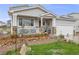 Beautifully landscaped yard with green grass, stone accents and a inviting porch with flower pot decor at 9674 Fox Den Dr, Littleton, CO 80125