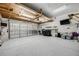 Spacious garage with epoxy floor, wood accents, and overhead lighting at 9674 Fox Den Dr, Littleton, CO 80125