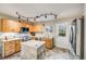 Well-lit kitchen featuring an island, stainless steel appliances, wooden cabinets, and easy access to the outdoors at 9674 Fox Den Dr, Littleton, CO 80125