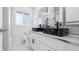 Modern bathroom featuring dual sinks, stone countertops, and sleek white cabinetry with brushed silver hardware at 555 Everett St, Lakewood, CO 80226