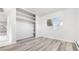 Well-lit bedroom features open closet with built-in shelves and new vinyl floors at 555 Everett St, Lakewood, CO 80226