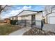 Charming single story home with white painted brick and a black iron fence at 555 Everett St, Lakewood, CO 80226