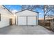 Detached two car garage with an adjacent wooden fence and concrete drive offers convenient parking and storage solutions at 555 Everett St, Lakewood, CO 80226