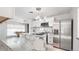 Open kitchen with white cabinets, stainless appliances, and marble countertops at 555 Everett St, Lakewood, CO 80226