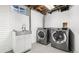 Basement laundry room features a new sink and modern washer and dryer, offering convenience and efficiency at 555 Everett St, Lakewood, CO 80226