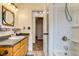 Bright bathroom featuring a granite countertop and view of the shower and door to another room at 5770 Waverley Ave, Firestone, CO 80504