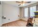 Bedroom featuring a ceiling fan, neutral carpet, two windows, and a wall sconce at 5770 Waverley Ave, Firestone, CO 80504