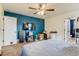 Bedroom featuring blue accent wall, ceiling fan, and an ensuite bathroom at 5770 Waverley Ave, Firestone, CO 80504