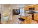 Spacious kitchen and dining area with tile floors, a central island, and access to the basement stairs at 5770 Waverley Ave, Firestone, CO 80504