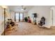 Spacious living room with carpet flooring, a ceiling fan, and ample natural light from the large windows at 5770 Waverley Ave, Firestone, CO 80504