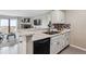 Bright kitchen with white cabinets, stainless steel appliances, and bar-top seating at 7468 S Alkire St # 204, Littleton, CO 80127