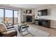 Cozy living room with stone fireplace, balcony access, and modern entertainment center at 7468 S Alkire St # 204, Littleton, CO 80127