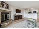 Inviting living room area with a stone fireplace, modern entertainment, and kitchen access at 7468 S Alkire St # 204, Littleton, CO 80127