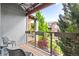 Cozy balcony with wooden floors, metal railings, and views of lush greenery and neighboring buildings at 84 Spruce St # 707, Denver, CO 80230