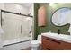 Modern bathroom featuring a sleek vanity, round mirror, and a tiled shower with glass enclosure at 84 Spruce St # 707, Denver, CO 80230