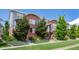 A row of brick townhomes featuring lush landscaping and modern design elements at 84 Spruce St # 707, Denver, CO 80230