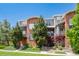 A modern townhome featuring brick accents, steel railings, and manicured landscaping at 84 Spruce St # 707, Denver, CO 80230