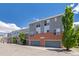 Exterior view of modern townhomes featuring brick accents, gray siding, and well-manicured landscaping at 84 Spruce St # 707, Denver, CO 80230