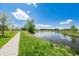 Picturesque pond and walking path surrounded by lush green grass and blue skies at 84 Spruce St # 707, Denver, CO 80230