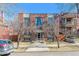 Brick apartment building with symmetrical facade, tall windows, and small front yard on a sunny day at 1330 Elizabeth St # 8, Denver, CO 80206