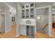 Hallway bar area with a beverage fridge, white cabinets, herringbone backsplash, and glass shelving for an elegant look at 2558 Premier Pl, Boulder, CO 80304