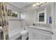 Bathroom with white vanity, tiled shower-tub, and stylish mirror with modern lighting at 2558 Premier Pl, Boulder, CO 80304